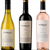 Three Pedregal wine bottles on a white background: a yellow-green Chardonnat, a dark red Tannat 2020, and a pale pink Rosé. The center bottle is slightly larger and more prominent than the other two.